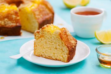 Lemon bundt cake with cup of tea. Blue background. Close up.