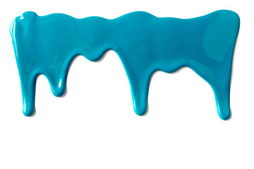 Blue paint leaking down white background. Close up.