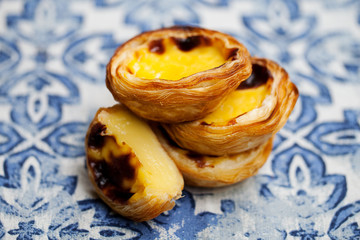 Egg tart, traditional Portuguese dessert, pastel de nata. Blue background. Close up.