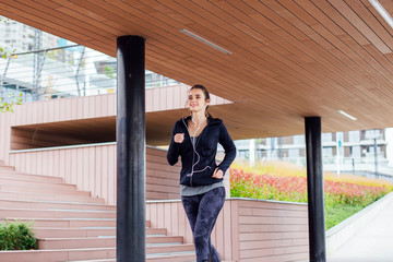 Fototapeta na wymiar Young woman running outdoor in urban enviroment