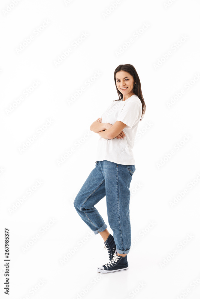 Wall mural Full length of a smiling young casual woman standing