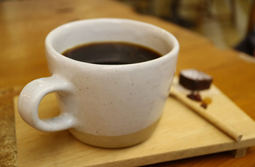 Closeup a cup of Hot black coffee served on wooden tray