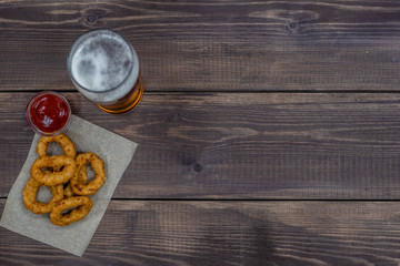 Snacks with beer on dark wooden background. Top view. Empty space for text