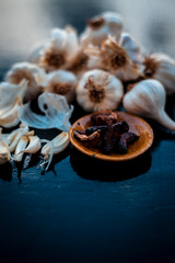 Fresh garlic bulbs or lasun on wooden surface along with some fried garlic cloves in small plate.Used to treat cholesterol.
