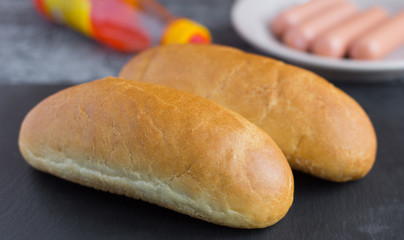 fresh crispy buns for making hot dogs on a gray background