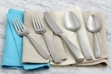 silverware and hemstitch napkin on antique carrara marble