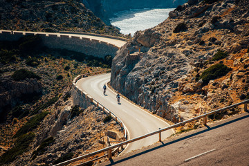 Road bikers on the road on Balearic Islands. Sea in Background. Cap de Formentor. Mallorca, Majorca, Spain