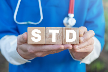 STD sexually transmitted diseases health concept on a wooden blocks in a doctor hands.