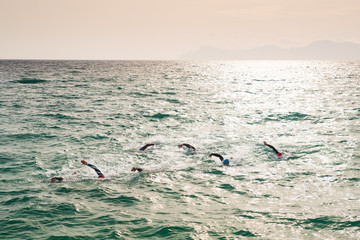 Triathlon swimmers train in open water in the sea. Mallorca, Spain