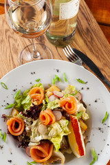 Seafood salad with white wine on a wooden table