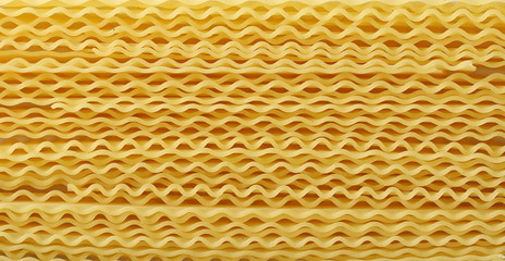 Uncooked Italian pasta mafaldine background and texture, top view