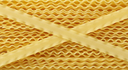 Uncooked Italian pasta mafaldine background and texture, top view
