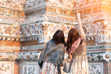 Young woman traveler traveling in Wat Arun Ratchawararam Ratchawaramahawihan Temple in bangkok