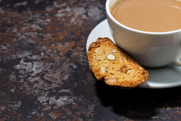 cup of coffee with milk and Italian cookies cantucci on dark background