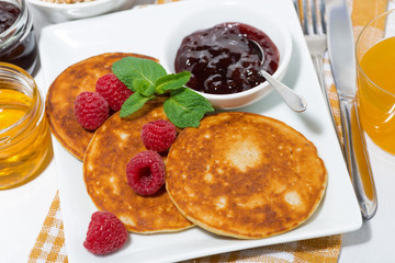 delicious pancakes with raspberries and jam for breakfast on the plate