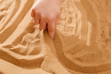 Sand therapy, child's hands are painted on table with sand