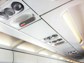 No smoking signs and controls for adjusting the air conditioning and personal lights inside a commercial aircraft.