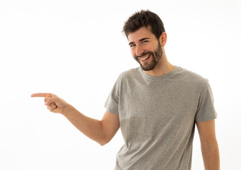 Charming smiling young man pointing finger at empty copy space for advertisement
