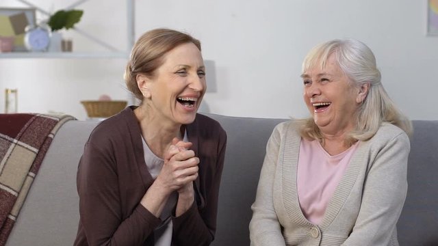 Aged female women laughing remembering youth, nursing home leisure, friendship
