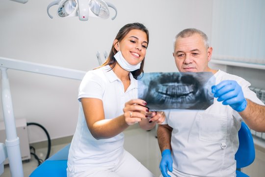 Two dentists look at the x-ray of the teeth. Dental clinic