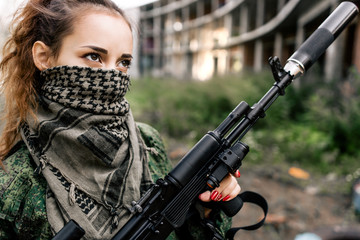 Armed woman in camouflage holding a rifle close-up black and white photo. Women's army