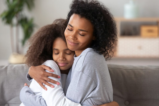 African American mother and daughter embracing, enjoying moment together