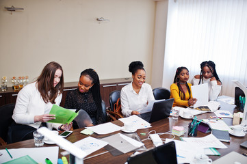 Multiracial women colleagues, crew of divercity female partners in office sit at the table.