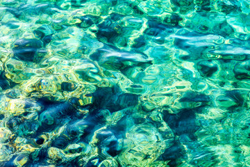 Fototapeta na wymiar Transparent turquoise sea water with sun glare, background.