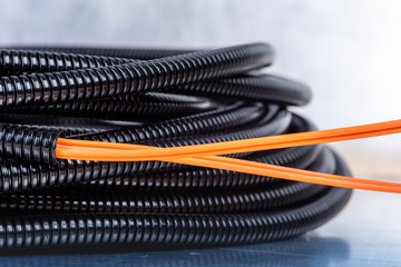 Cable in black flexible corrugated tube ready to be installed in telecommunication network