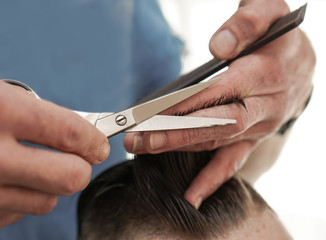 Haircutting process in the hairdresser. man in the salon smoothes his hair. Hands with scissors. Stock photos for design