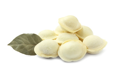 Pile of raw dumplings with bay leaf on white background
