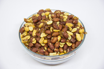 Roasted peanuts in glass bowl on white background