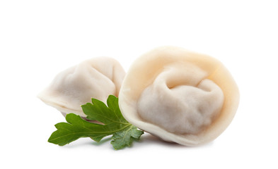 Boiled dumplings and parsley leaves on white background