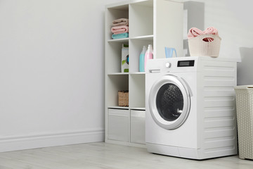 Modern washing machine in laundry room interior. Space for design