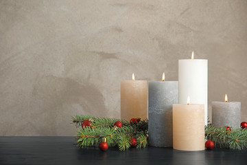 Burning candles with Christmas decoration on table. Space for text