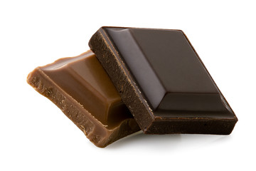 Square of dark chocolate resting on a square of milk chocolate isolated on white. Rough edges.