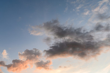 Fluffy dark clouds with sunshine in sky