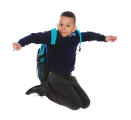 Full length portrait of cute African-American boy in school uniform jumping on white background