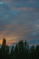 Landscape with dramatic light - beautiful golden sunset with saturated sky and clouds.