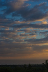 Landscape with dramatic light - beautiful golden sunset with saturated sky and clouds.