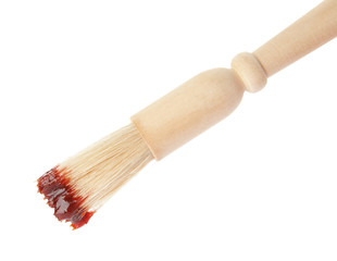 Basting brush with barbecue sauce on white background