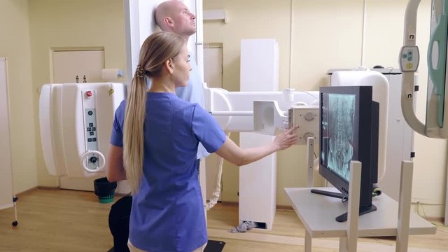 Female Technician ajusts X-ray Machine