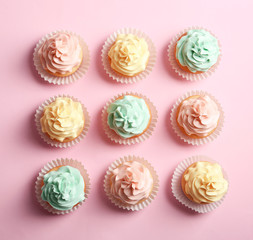 Flat lay composition with delicious cupcakes on color background