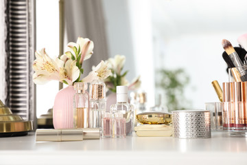 Luxury makeup products and accessories with perfumes on dressing table