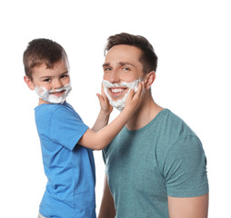 Happy dad and son with shaving foam on faces against white background