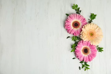 Fotobehang Flat lay composition with beautiful bright gerbera flowers on wooden background. Space for text © New Africa