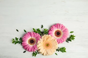 Fotobehang Flat lay composition with beautiful bright gerbera flowers on wooden background, top view. Space for text © New Africa