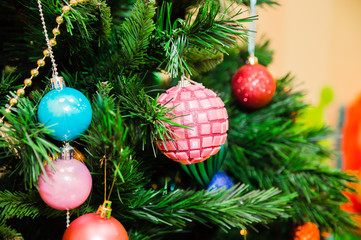Obraz na płótnie Canvas Christmas tree decorated with blue, pink and red balls