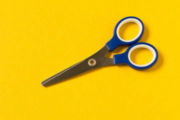 Scissors on an yellow background. Colored baby scissors.