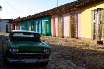 Street view of colored houses in Trinidad with old-timer car
